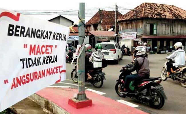 Terpajang Spanduk ‘Berangkat Kerja Macet, Tidak Kerja Angsuran Macet’, Keluhan Warga Pangkal Jembatan Musi 4 